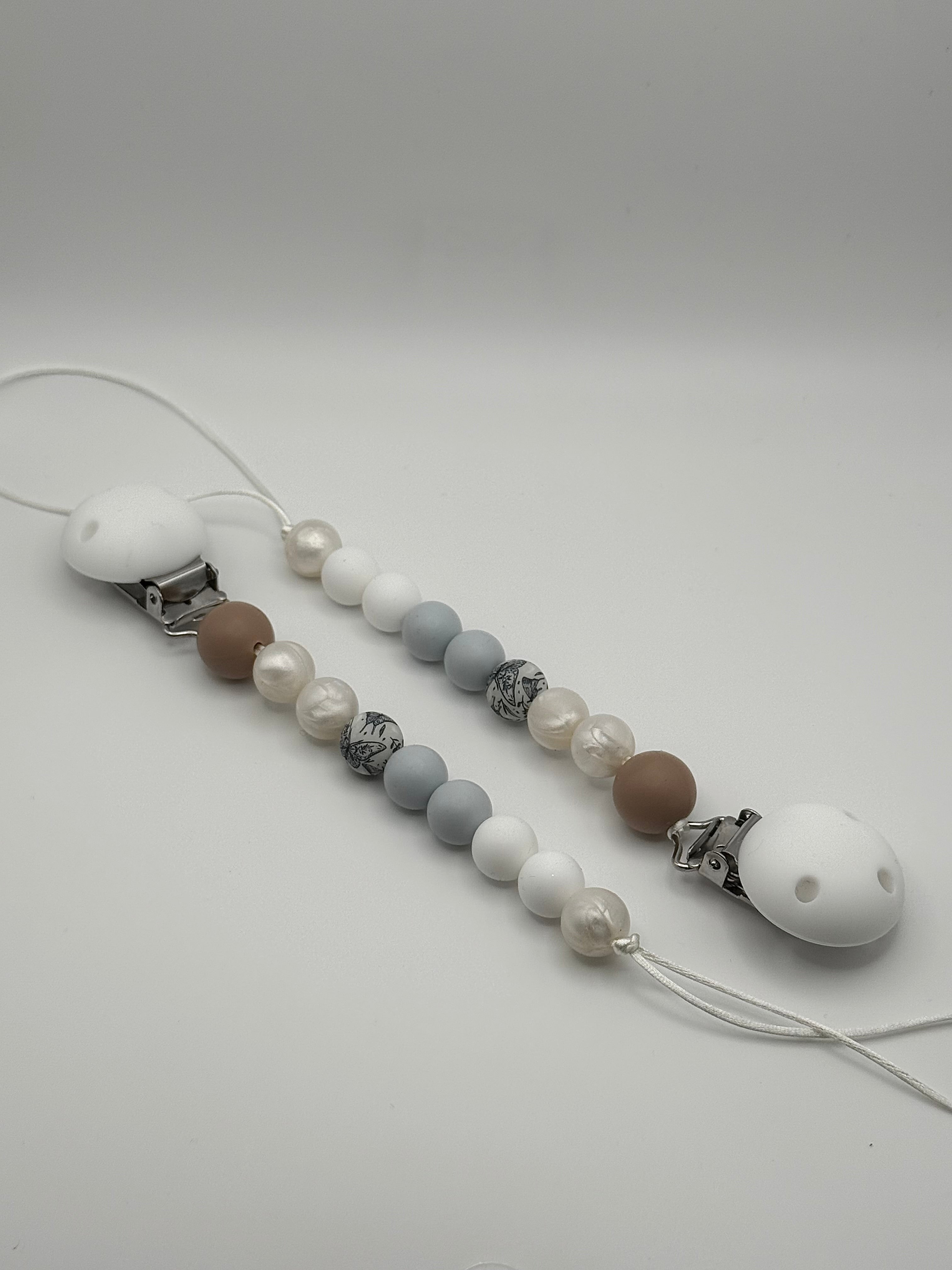 Attache-suce en silicone alimentaire, sécuritaire et durable. Confection québécoise. Parfait pour garder la suce propre et accessible.