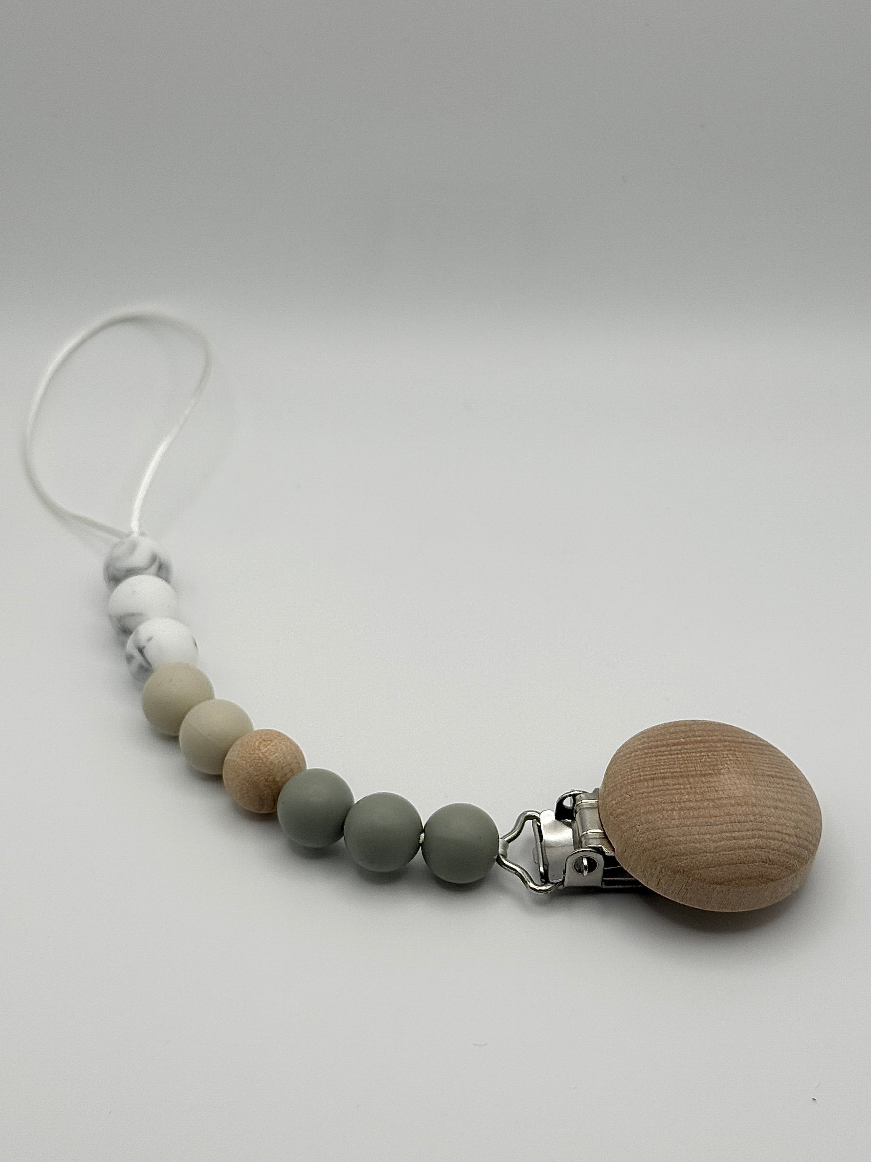 Attache-suce en silicone alimentaire, sécuritaire et durable. Confection québécoise. Parfait pour garder la suce propre et accessible.